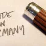 Close-up of brown Graf von Faber-Castell No.III desk pencil with silver ferrule and eraser writing on paper