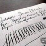 Diamine Green Black fountain pen ink writing sample on lined paper with pen strokes and loops