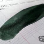 Diamine Green Black fountain pen ink swatch on lined paper showing shading and depth