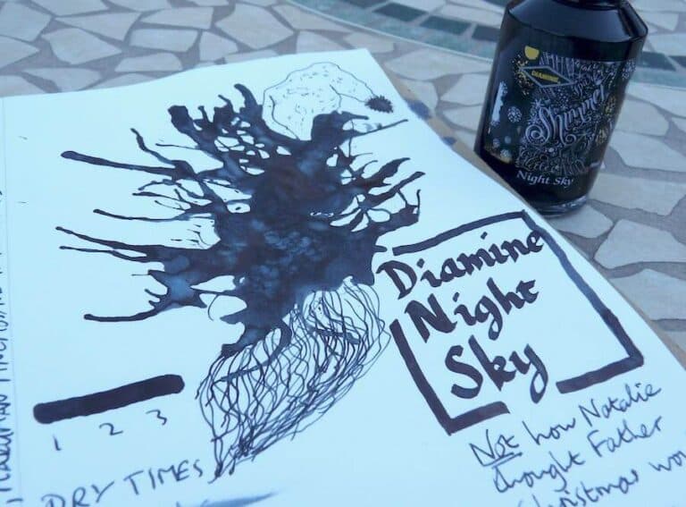 Diamine Night Sky Shimmertastic ink bottle with handwritten ink swatch and notes on paper