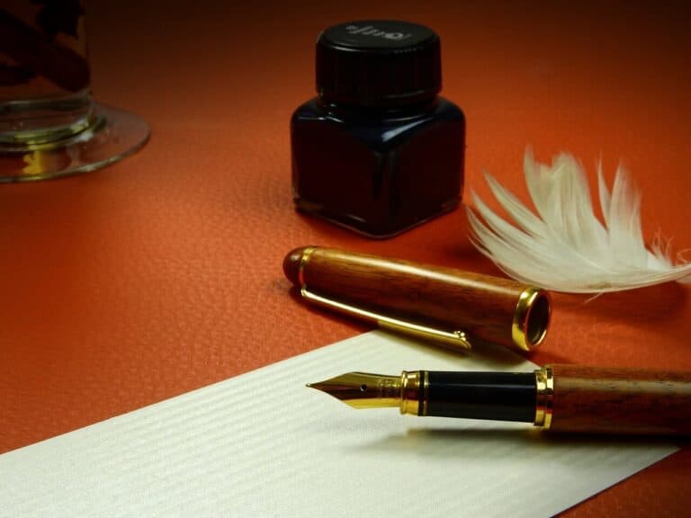 Fountain pen, bottle of ink and a feather