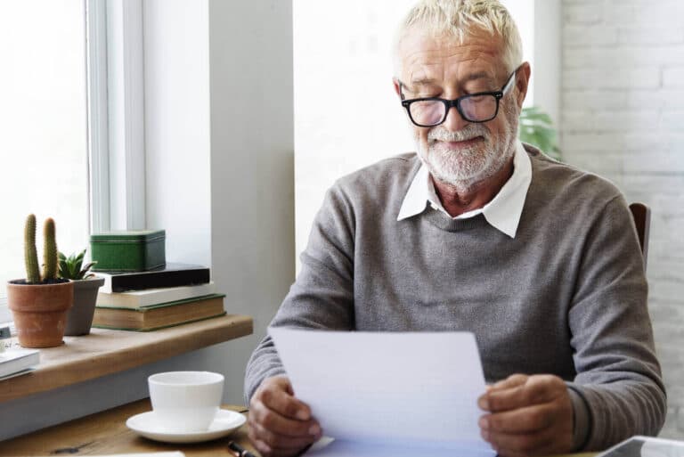 Elderly man reading coronavirus letter from neighbour