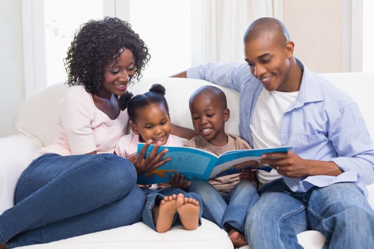 A Black family reading a picture book together.