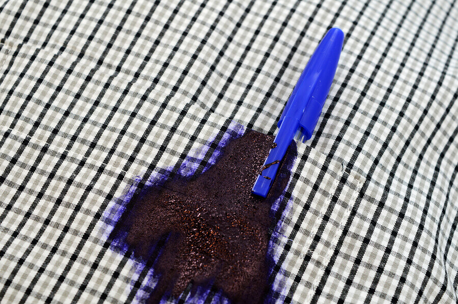 a ballpoint pen leaking in the pocket of a shirt