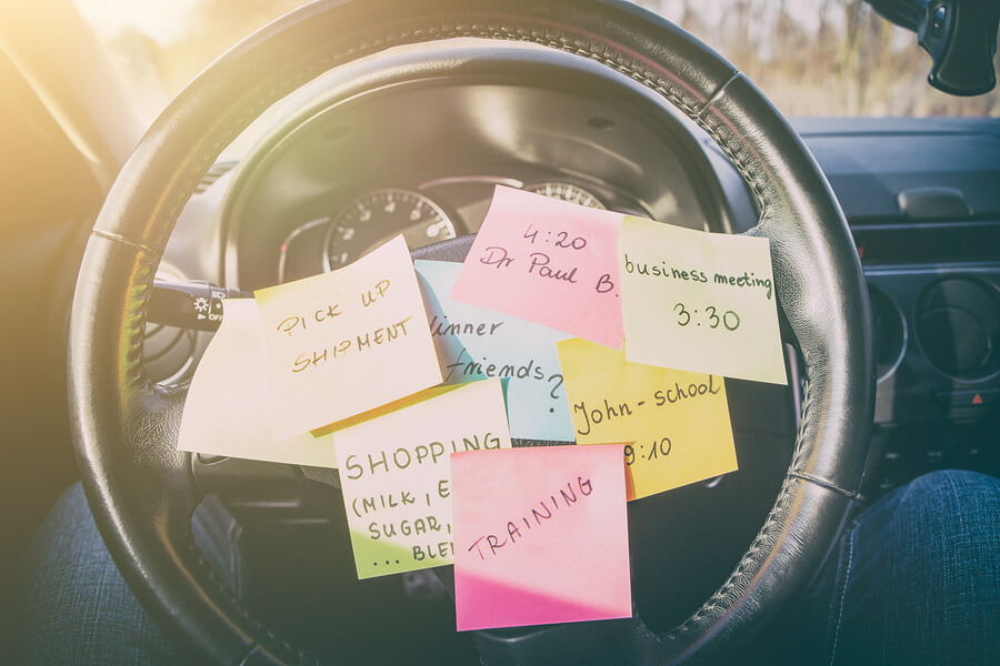A car's steering wheel covered in post-it notes