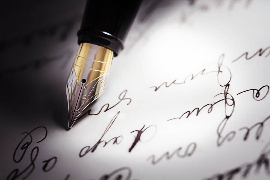 a fountain pen nib with handwriting on paper