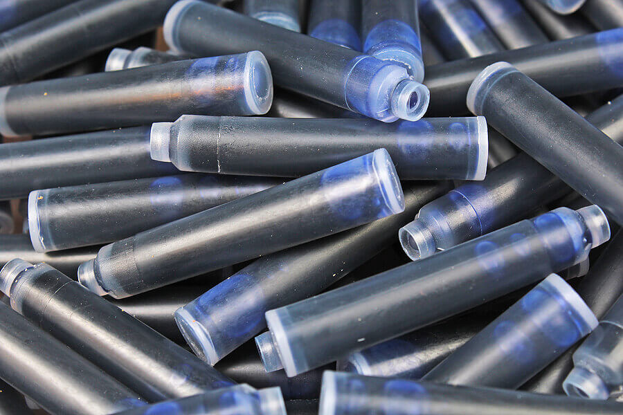 Pen ink Cartridge. Close up of the nib of a fountain pen ink cartridges. Inks as background.