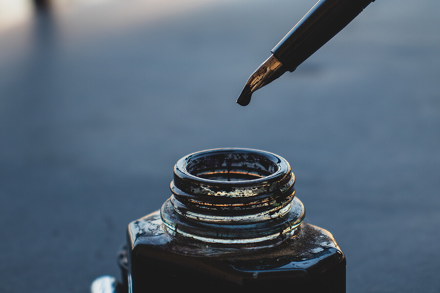 fountain pen dripping ink in an inkwell