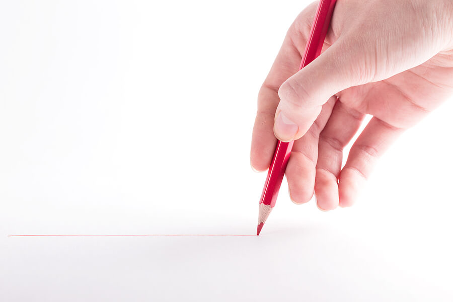 hand with the red pencil on a white background