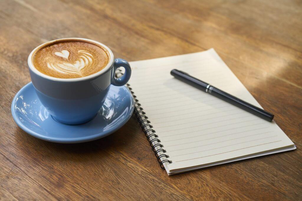 pen, notepad and coffee cup