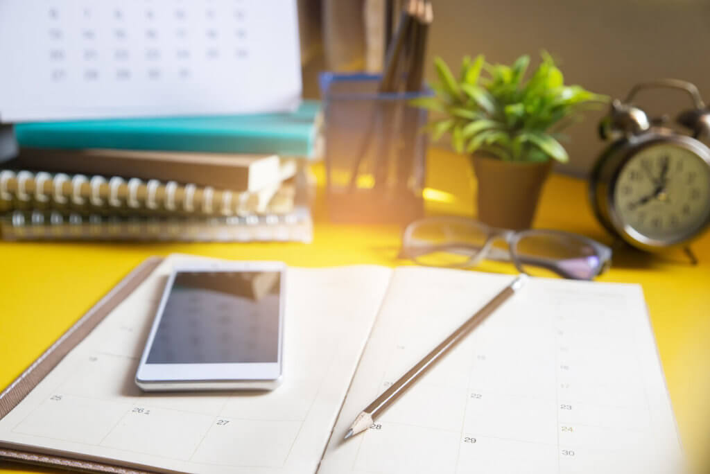A diary, pencil and mobile phone on a desk