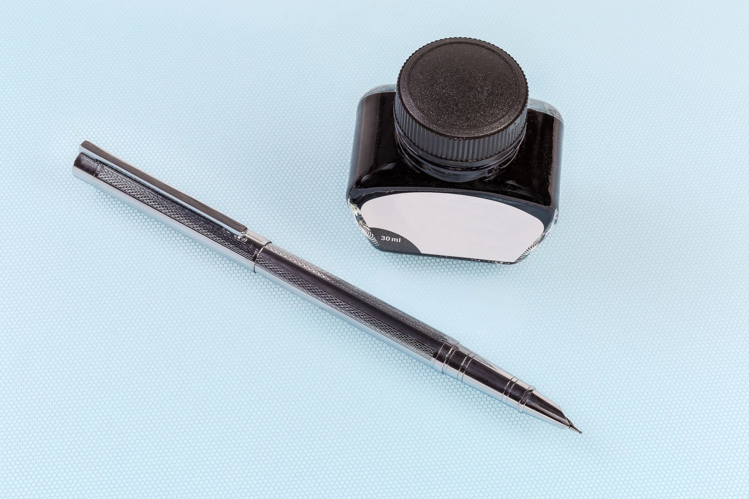 Decorative image of fountain pen and bottle of ink.