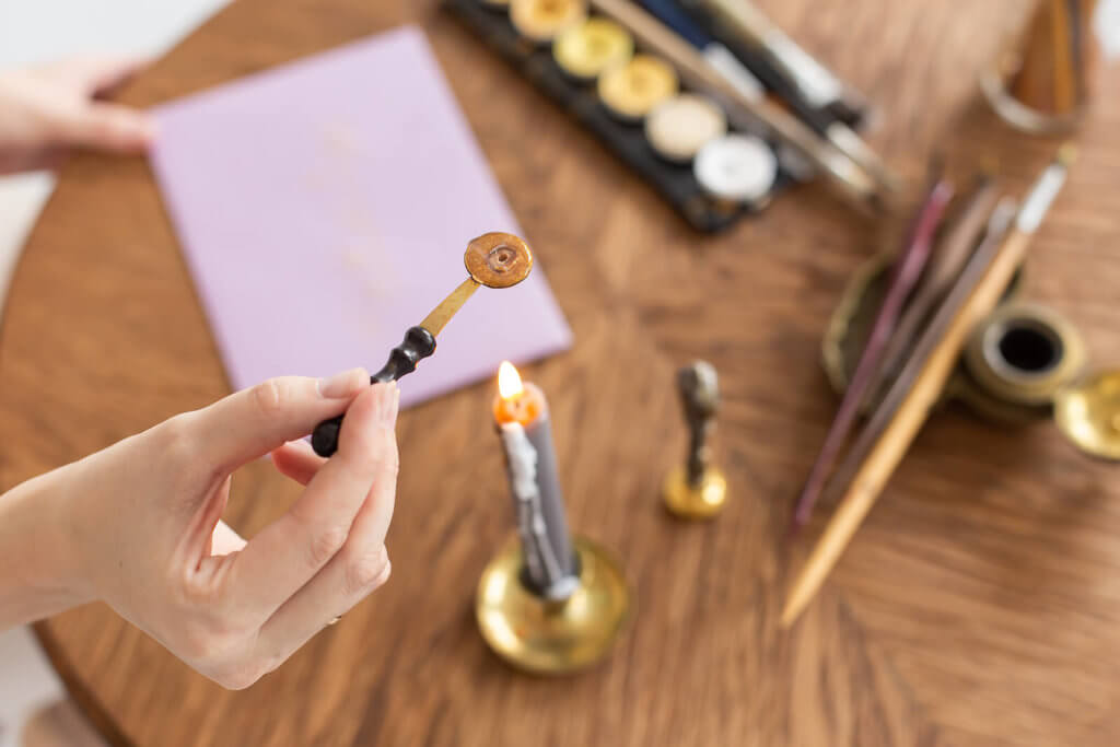 heating gold wax over a candle for a wax seal