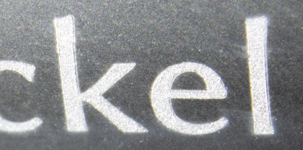 A close up of the engraving. You can just make out the dots that make up the letters.