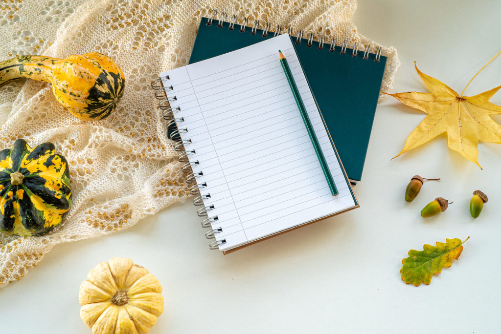 An open notebook surrounded by Halloween and fall decor.