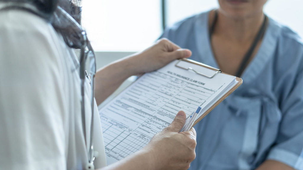 A doctor and nurse holding a clipboard and pen