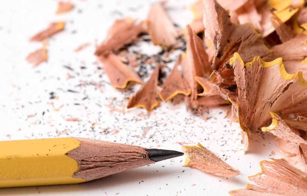 A yellow pencil and its shavings after being sharpened.
