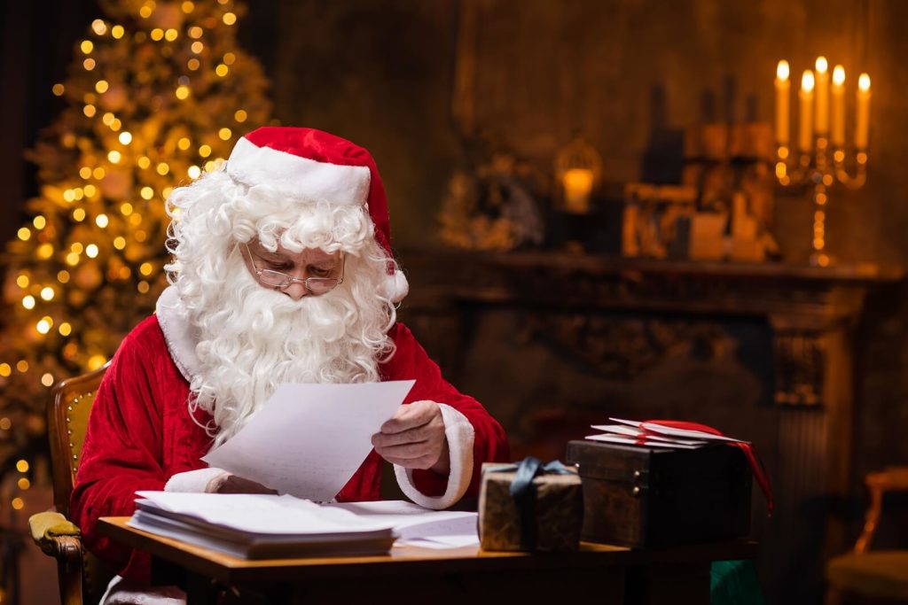 Santa Claus sat at his desk, reading a letter from a child.