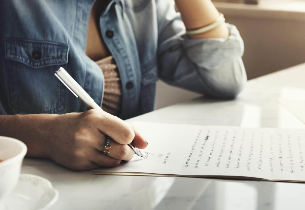 A woman writing a letter to a pen pal.