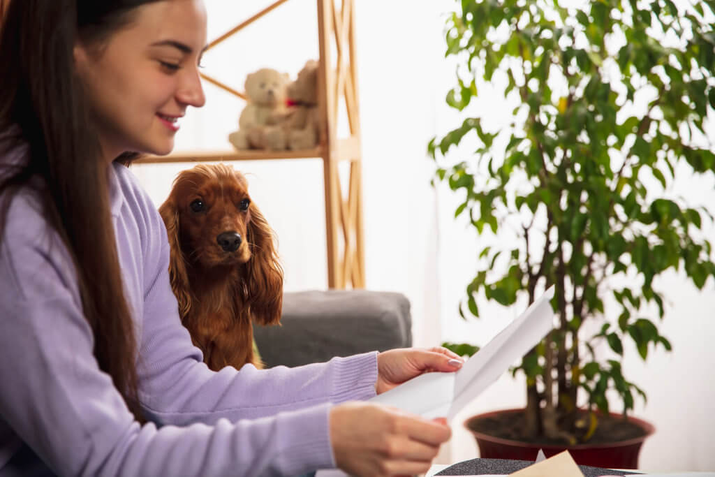 A smiling woman reading a letter with a dog
