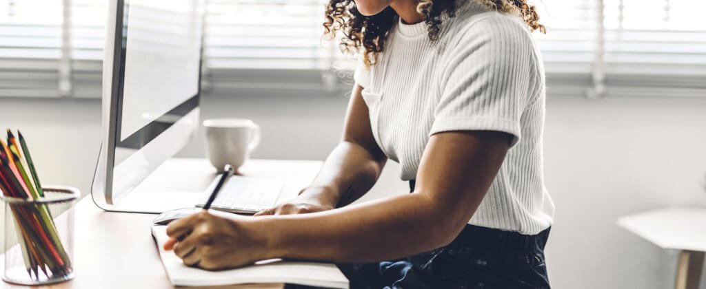 woman writing at her desk